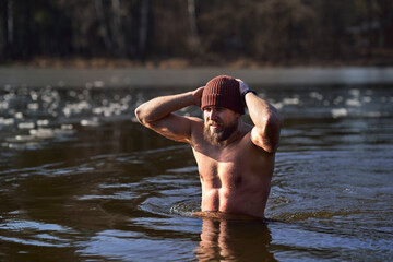 Caucasian adult man swimming in frozen lake
