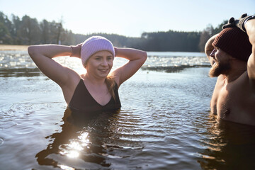 Caucasian couple swimming in frozen lake