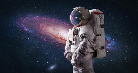 Fototapeta na wymiar Astronaut in bright space with galaxy Andromeda. Spaceman with starry and galactic background. Sci-fi wallpaper. Elements of this image furnished by NASA