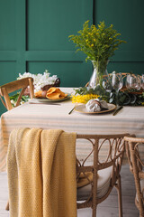 Dining table with beautiful setting near green wall