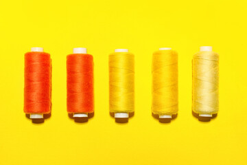 Different sewing threads on yellow background