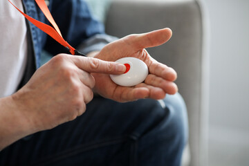 Man pushing panic button on emergency equipment for elderly people