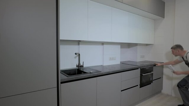 The builder checks the quality of the installation of kitchen furniture construction