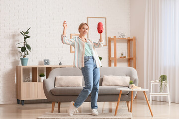 Woman with modern wireless portable speaker dancing in room