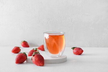 Glass of fresh strawberry kombucha on light background