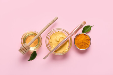 Bowls with turmeric mask, powder and honey on pink background