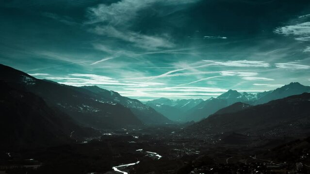 Nuages d&eacute;filant sur la plaine du Rh&ocirc;ne entour&eacute;e de montagnes en Valais, Suisse.