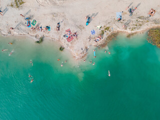 aerial view of people swimming sunbathing resting at sandy beach