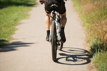 cyclist rides on an asphalt road during the day