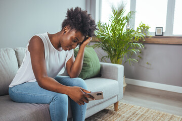 Depressed sad attractive woman crying on sofa couch at home feeling lonely tired and worried...