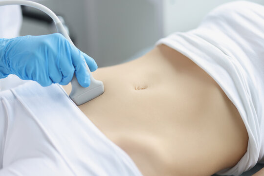 Hands on a woman's stomach, ultrasound abdominal cavity