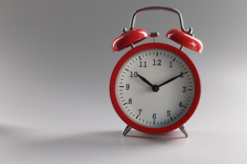 Close-up of a red alarm clock on a gray background