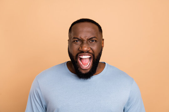 Portrait of attractive mad fury crazy guy bad reaction shouting grimacing isolated over beige pastel color background
