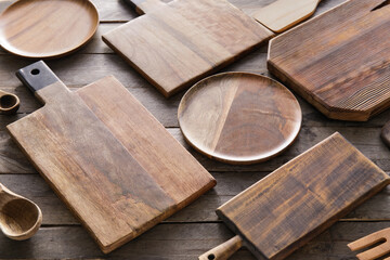 Different cutting boards and plates on wooden background