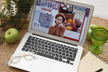 Laptop with eyeglasses, notebook and accessories of blogger on carpet