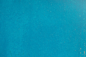 Texture is blue paint. Background is blue wall. Rough surface. Homogeneous coat of paint.