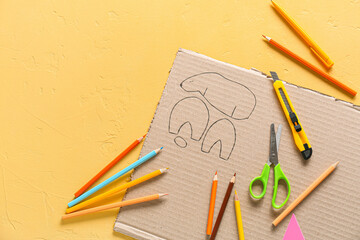 Stationery supplies for handcraft and cardboard toy drawing on color background