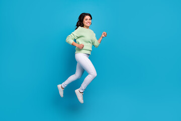 Full size profile photo of funny young brunette lady run wear shirt pants shoes isolated on blue background