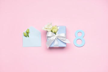 Composition with gift box, flowers and envelope for International Women's Day on color background