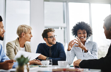 With the help of the whole team, anything is possible. Shot of a group of businesspeople sitting...