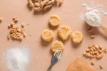 Uncooked peanut cookies and ingredients on beige background