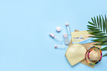 Composition with empty travel cosmetics bottles, ticket and palm leaf on color background