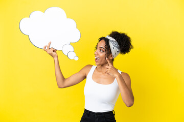 Young african american woman isolated on yellow background holding a thinking speech bubble with surprised expression