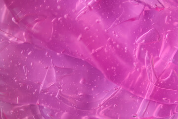 Texture of transparent violet pink gel with air bubbles and waves. Concept of skin moisturizing,...