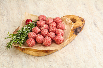 Raw uncooked beef meatballs served rosemary