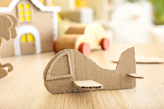 Handmade cardboard plane on wooden table