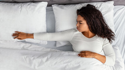 Black woman suffering from loneliness in bed