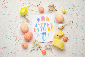 Fototapeta na wymiar Beautiful Easter composition with greeting card, painted eggs, bunny and flowers on light background