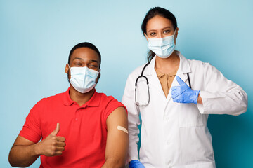 General Practitioner And Vaccinated Patient Gesturing Thumbs-Up After Vaccination, Studio
