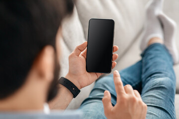 Unrecognizable guy browsing smartphone with black screen, checking new app or scrolling website