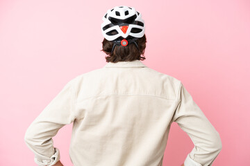 Senior dutch man with bike helmet isolated on pink background in back position