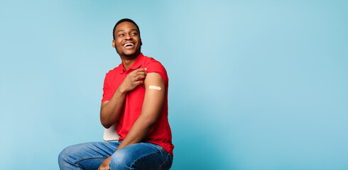 African American Guy Showing Arm After Vaccine Injection, Blue Background