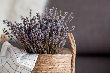 Provence. A wicker basket with a bouquet of lavender in the living room interior close-up. The...