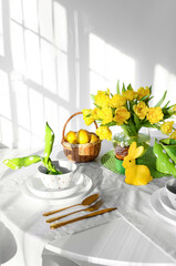 Beautiful table setting for Easter celebration on table in light room