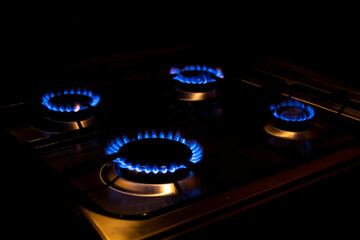 Four burning burners at night. Bright fire. The concept of expensive gas and energy resources. Increasingly expensive natural gas. Home modern gas stove.