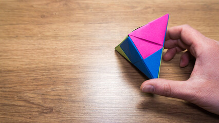 Man hält gefalteten Origami 5 eckigen Würfel in der Hand mit Textfreiraum