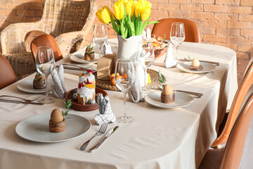 Stylish setting on dining table served for Easter celebration in room