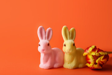 Cute Easter bunnies and flower on orange background
