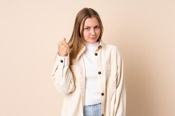 Teenager Ukrainian girl isolated on beige background with unhappy expression