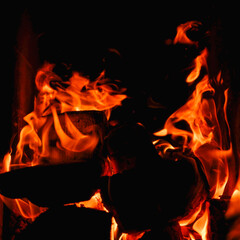 Burning firewood and coals in a stone stove. Brick oven on wood. Long tongues of flame of burning...