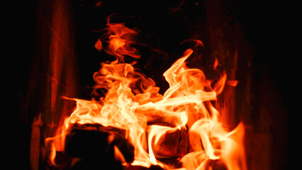 Burning firewood and coals in a stone stove. Brick oven on wood. Long tongues of flame of burning fire
