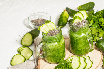 Green smoothie with cucumber in a glass jar. Fresh ripe vegetables, greens, and chia seeds