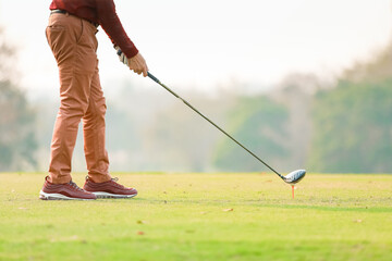 Man hitting driver on a golf course in the morning