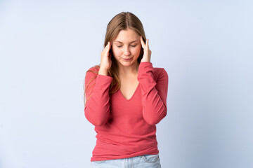 Teenager Ukrainian girl isolated on blue background with headache