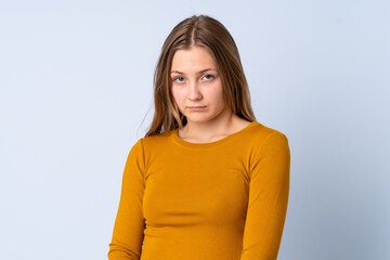 Obraz premium Teenager Ukrainian girl isolated on blue background with sad expression