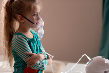 cute little girl is sick. lung disease, covid-19. child does the inhalation procedure with nebulizer of the respiratory tract. treating child for cough. compression inhaler. health concept. isolated - obrazy, fototapety, plakaty